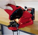 Kettingzaag slijper in rood, met een hand die de machine bedient en vonken die vliegen.