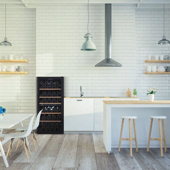 Zwarte wijnkoelkast in moderne witte keuken met tegels, houten vloer en houten krukken.