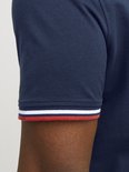 Donkerblauwe polo met rode en witte strepen op de mouwboord.