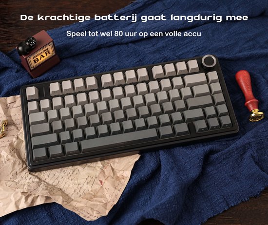 Zwart toetsenbord met grijze toetsen, gelegen op een blauwe stof.