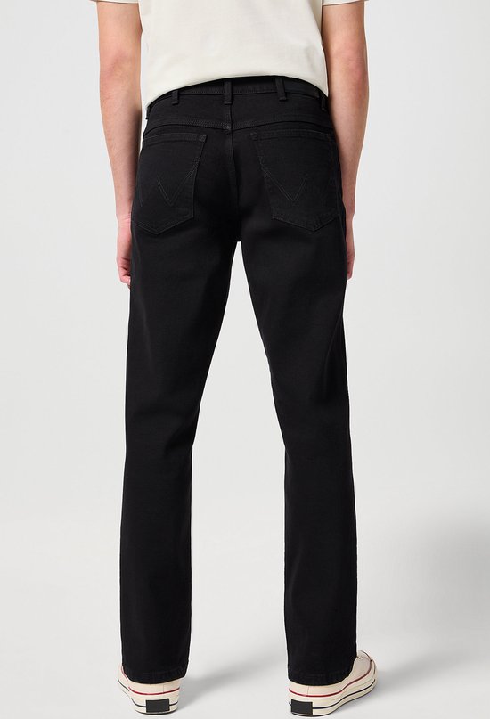 Achterkant van een man in een zwarte jeans.