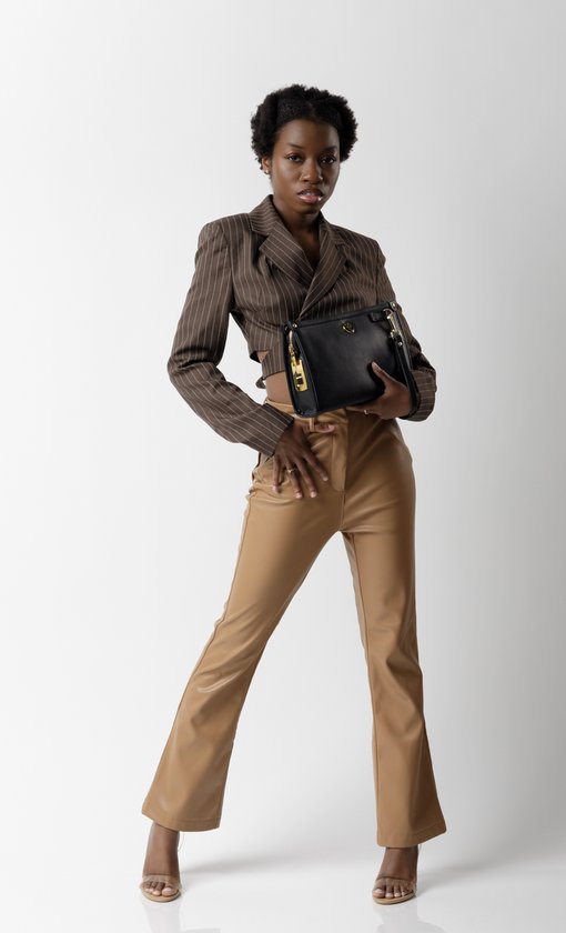 Zwarte leren clutch met gouden rits en logo, gedragen door een model met bruin gestreept jasje en beige pantalon.