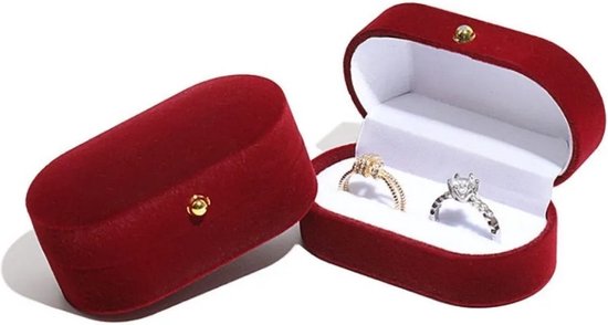 Rood fluwelen juwelendoosje open, met twee ringen erin, goud en diamant.