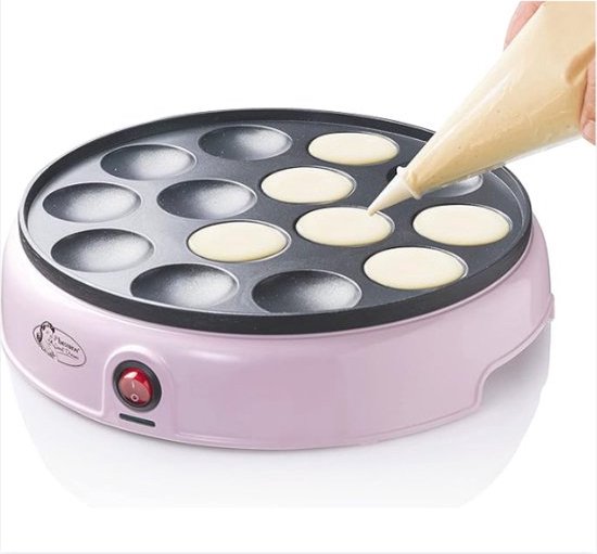 Roze pannenkoekenmaker met twaalf ronde bakjes, waarbij deeg in de bakjes wordt gespoten.