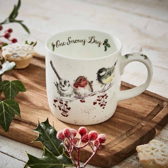 Witte mok met 'One Snowy Day' tekst en drie vogels op tak met rode bessen, op een houten plank met kerstdecoratie.