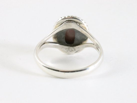 Bague en argent avec une pierre rouge à l'arrière.