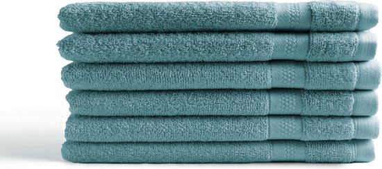 Pile de six gants de toilette bleu denim, chacun avec un bord tissé.