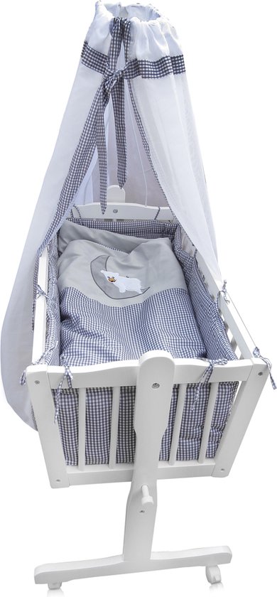 Witte wieg met blauw-wit geblokte bekleding, een dekbed met maan-schapen motief en een hemel.