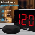 Digitale wekker met rode cijfers toont 12:00, naast een zwarte trilschijf en icoontjes.