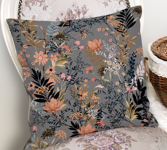 Kussen met een bloemenprint op een grijze achtergrond, geplaatst op een stoel met bloemenpatroon.