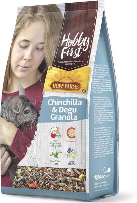 Vrouwenhand houdt een chinchilla vast naast een zak Hobby First Chinchilla & Degu Granola voer met vruchten en kruiden.