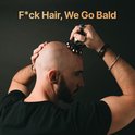 Man scheert zijn hoofd met de Skull Master scheerapparaat. De tekst 'F*ck Hair, We Go Bald' staat in beeld.
