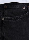 Donkere zwarte jeans met koperkleurige knopen.