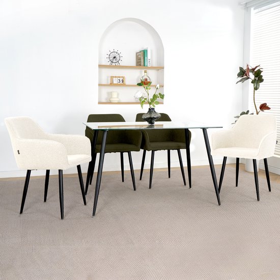 Eetkamer met een glazen tafel en vier stoelen, waarvan twee donkergroen en twee crème boucle.