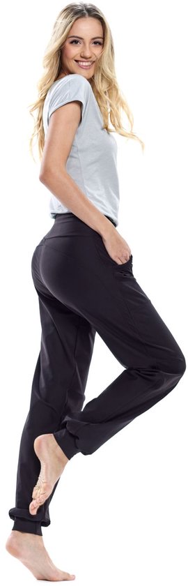 Model in een zwarte, nauwsluitende sportbroek met hoge taille en steekzakken. Ze draagt een lichtgrijs T-shirt.