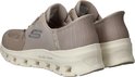Een paar beige Skechers Slip-ins met een dikke witte zool met GLIDE-STEP opdruk. De zijkant heeft een zilverkleurig Skechers logo.
