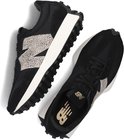 Een paar zwarte New Balance 327 sneakers met beige luipaardprint N-logo en witte zolen.