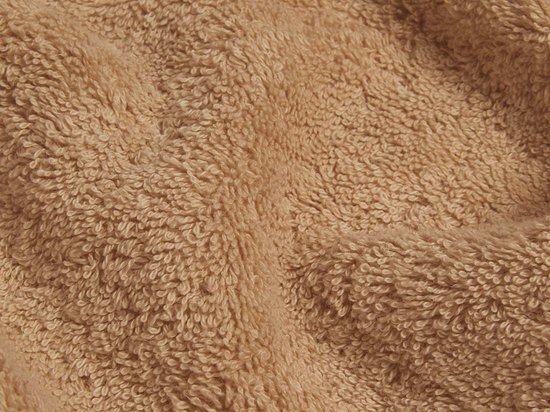 Gros plan sur la texture douce et pelucheuse d'une serviette éponge beige.