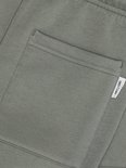 Close-up van de olijfgroene joggingbroek met een opgestikte zak en 'ONLY & SONS' label.