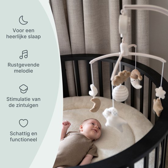 Muziek-mobiel in een zwart ledikantje met gebreide figuurtjes en informatie.