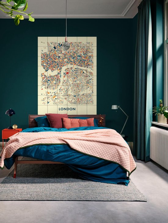 Une chambre avec une carte de la ville de Londres en bleu, orange et rouge sur fond crème, accrochée au mur.