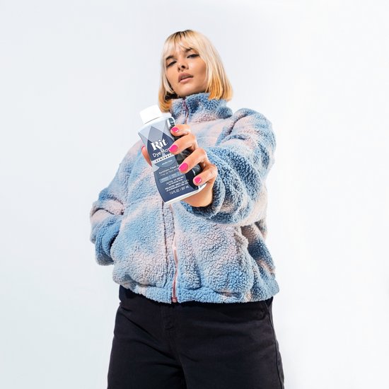 Model in om-en-om blauw/roze teddy jack met ritssluiting, met flesje Rit DyeMore in hand.