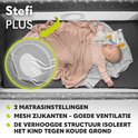 Baby slaapt in grijs campingbed Stefi PLUS, met mesh zijkanten en verhoogde bodem.