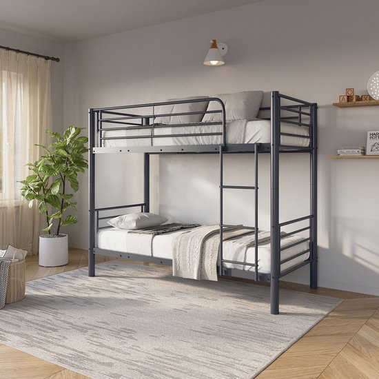 Donkergrijs metalen stapelbed met een lattenbodem, een ladder en beschermhekjes. Staat in een kinderkamer.