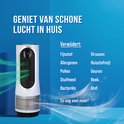 Witte luchtreiniger met groene luchtstroom die aangeeft dat hij stof, allergenen, pollen, huisstofmijt, bacteriën, virussen, geuren, rook en stof verwijdert.
