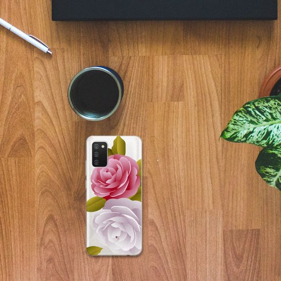 Telefoonhoes met roze en lichtpaarse rozen, liggend op een houten bureau naast een kopje en pen.