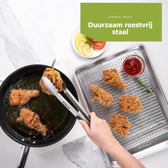 Tang met RVS greep haalt gefrituurde kip uit een pan met olie, naast een dienblad met kip.