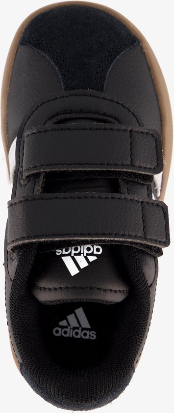 Binnenzijde van zwarte Adidas sneaker met klittenbandsluiting, bruine zool en Adidas logo op de binnenzool.