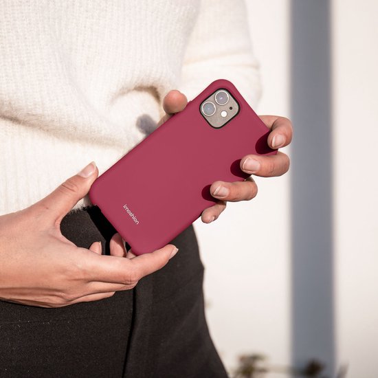 Mains tenant une coque de téléphone rose.