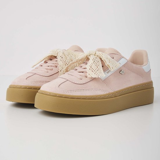 Roze suède sneakers met dikke bruine zool, witte accenten en geborduurde veters.