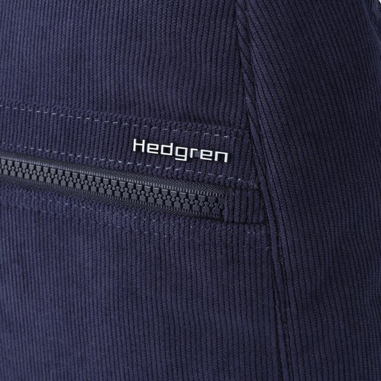 Detail van de donkerblauwe ribfluwelen stof en het Hedgren logo op de rugzak.