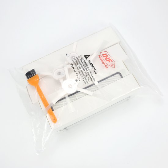 Een doorzichtige plastic verpakking met stofzuigeronderdelen: borsteltjes, witte zijborstels, een filter en een oranje schoonmaakborsteltje.