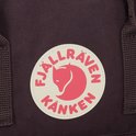 Close-up van het rode en witte Fjällräven Kånken logo op een paarse rugzak.
