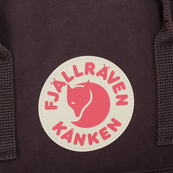 Close-up van het rode en witte Fjällräven Kånken logo op een paarse rugzak.
