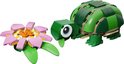 Groene LEGO-schildpad met grote ogen en een roze waterlelie ernaast.