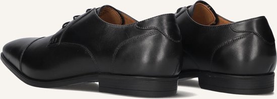 Achterkant van twee zwarte leren nette schoenen met details op de hiel.