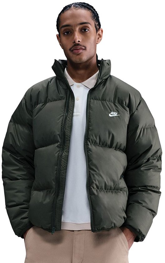 Man in donkergroen Nike pufferjack met Nike logo en een wit poloshirt.