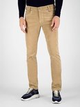 Voorkant van een man in beige corduroy broek en blauwe sneakers.
