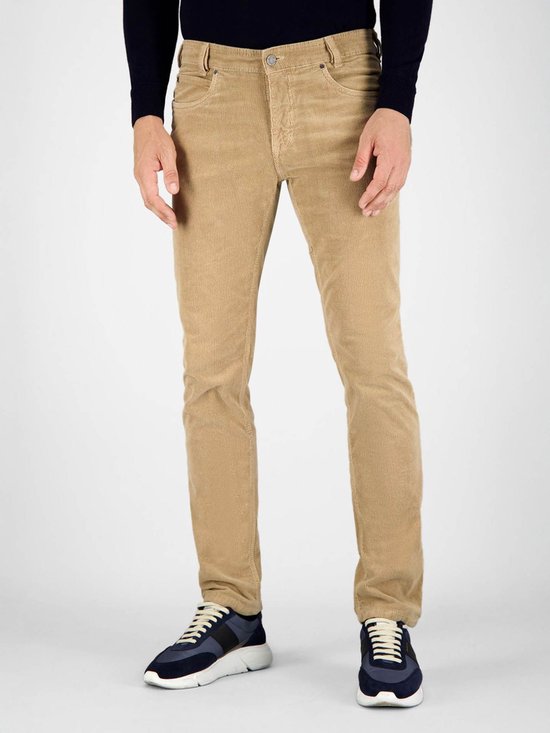 Voorkant van een man in beige corduroy broek en blauwe sneakers.