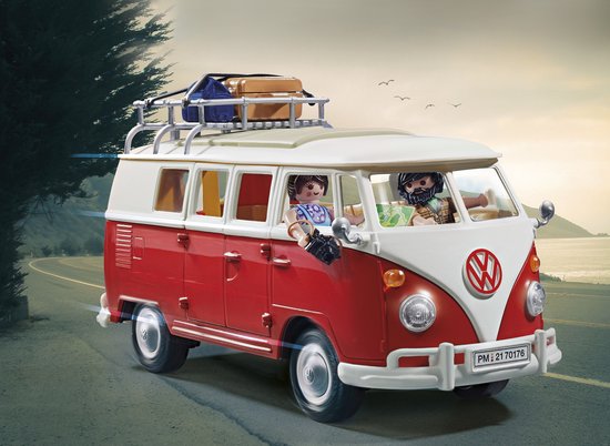 PLAYMOBIL Volkswagen T1 campingbus, rood en wit, met twee figuren op een landweg bij zonsondergang.