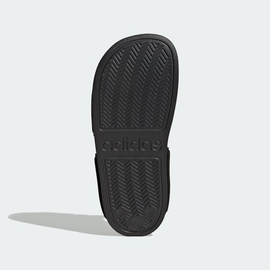 Zool van een zwarte Adidas Adilette sandaal met Adidas-logo.
