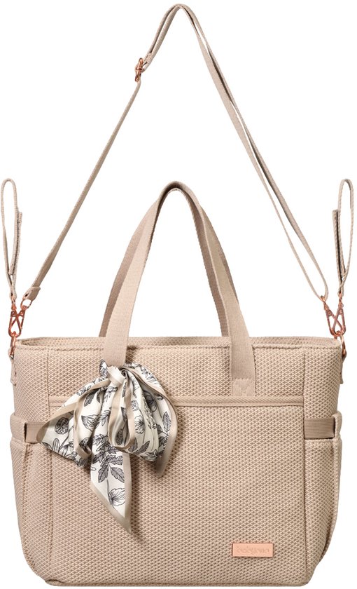 Beige luiertas met stoffen handvatten, een afneembare schouderriem en een sjaaltje met bloemenprint.