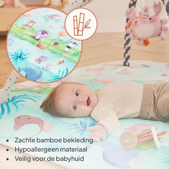Baby op speelkleed met bamboe symbool, zachte bekleding en dierendesigns.