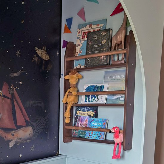 Wengé houten Montessori boekenrek met drie planken gevuld met kinderboeken en knuffels aan een muur met ruimtelijk behang.