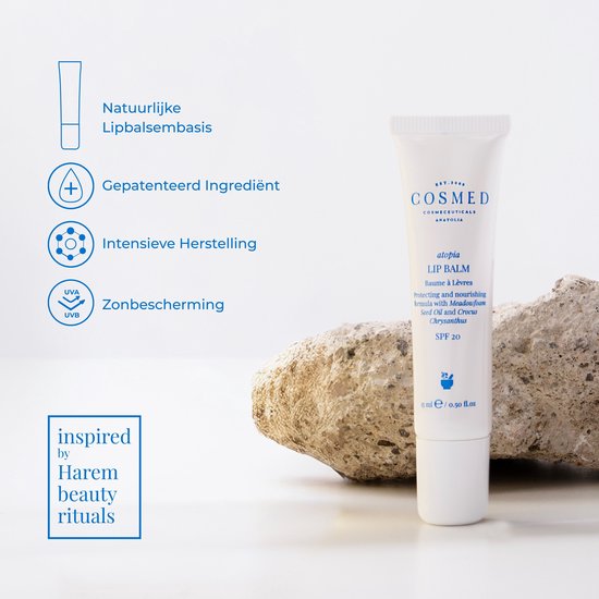 Witte tube Cosmed Lip Balm met blauwe tekst, SPF 20, naast een steen en iconen.