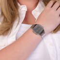 Zilverkleurig Casio horloge op de pols van een vrouw, gedragen met een wit shirt.